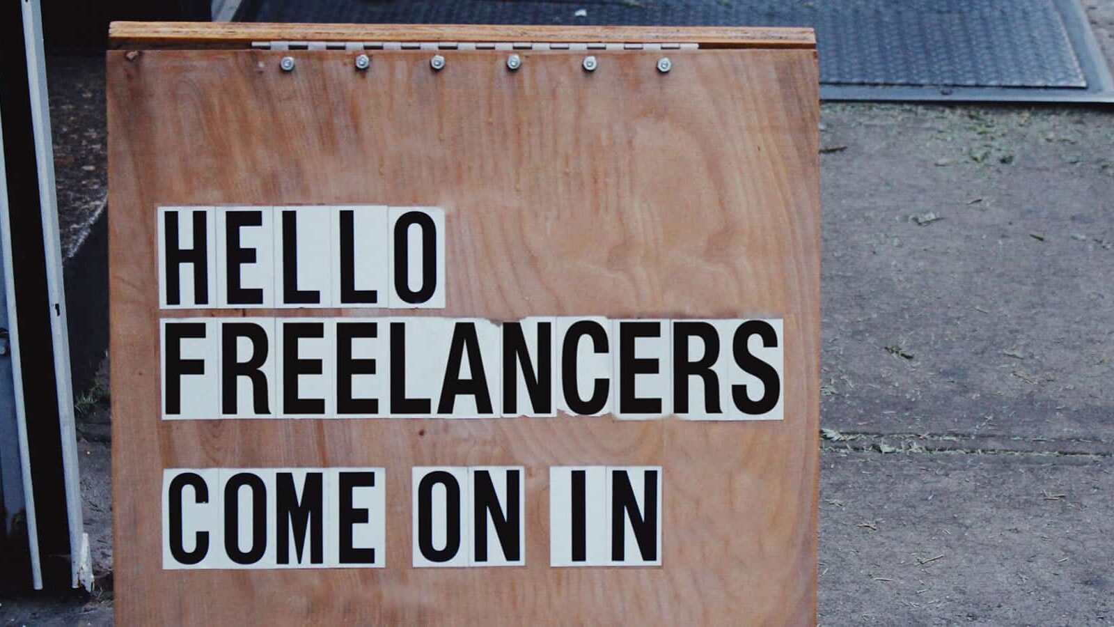 An image of a sign that says "Hello Freelancers, come on in" in an article about freelancer onboarding