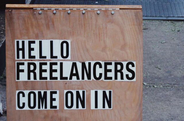 An image of a sign that says "Hello Freelancers, come on in" in an article about freelancer onboarding